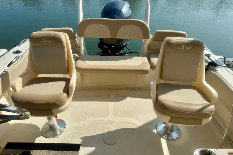 Slide: The Image of 2023 Scout 195 Sport Dorado boat interior with beige seating and outboard motor. - 1