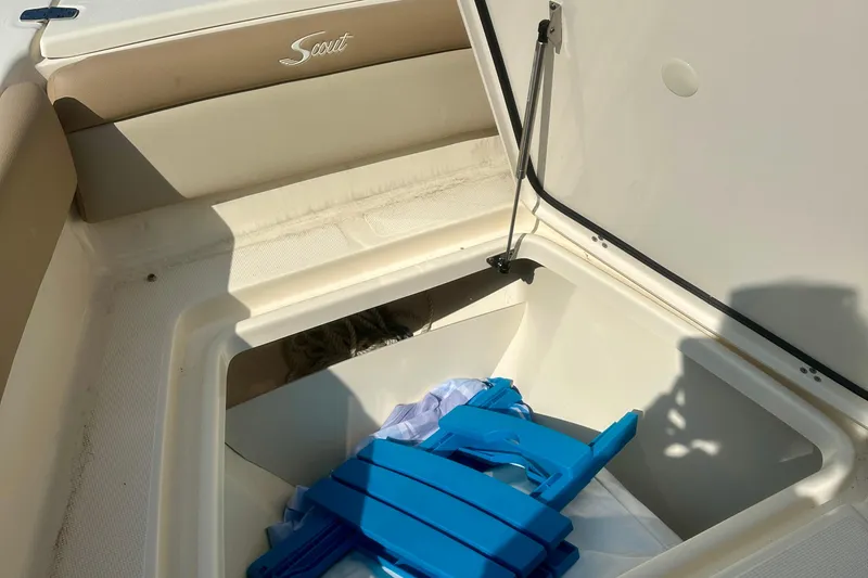 Slide: The Image of 2023 Scout 195 Sport Dorado boat storage compartment with blue accessories inside. - 9