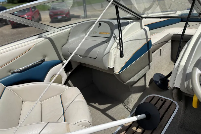 Slide: The Image of Interior of a 1995 Bayliner Maxum boat with white and blue seating. - 12