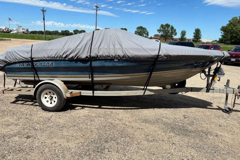 Slide: The Image of 1995 Bayliner Maxum boat on trailer, covered, parked outdoors on gravel. - 20