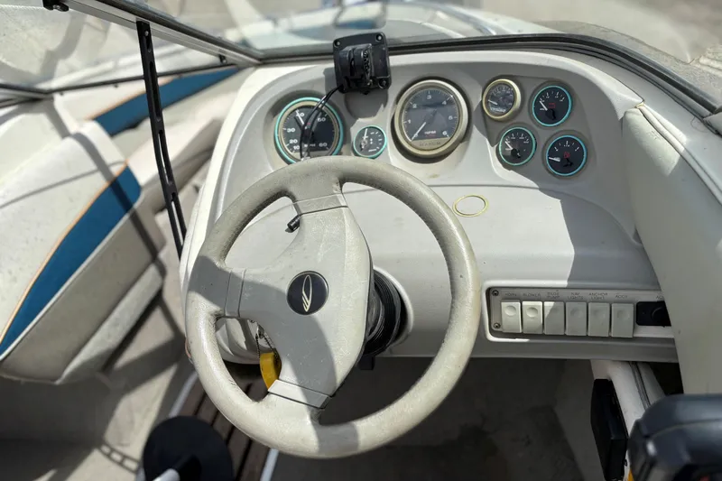 Slide: The Image of 1995 Bayliner Maxum boat dashboard with steering wheel and instrument panel. - 13