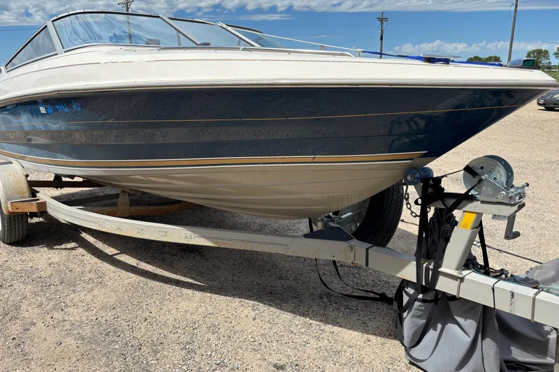 Slide: The Image of 1995 Bayliner Maxum boat on trailer under a partly cloudy sky. - 8