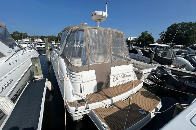 Slide: The Image of 2001 Larson Cabrio 330 boat docked at marina under clear blue sky. - 1