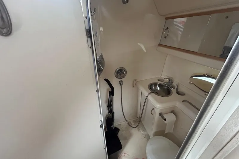 Slide: The Image of 2001 Larson Cabrio 330 boat bathroom with sink, toilet, and showerhead. - 16