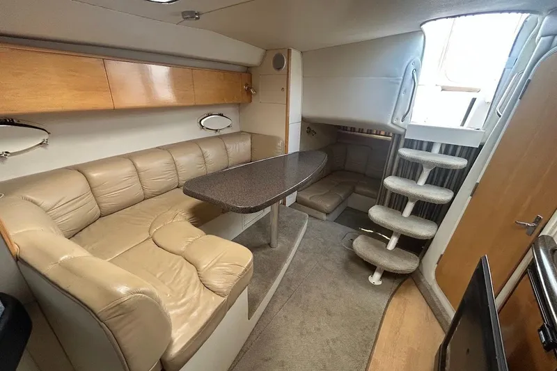 Slide: The Image of Interior of 2001 Larson Cabrio 330 boat with beige seating and compact dining area. - 17