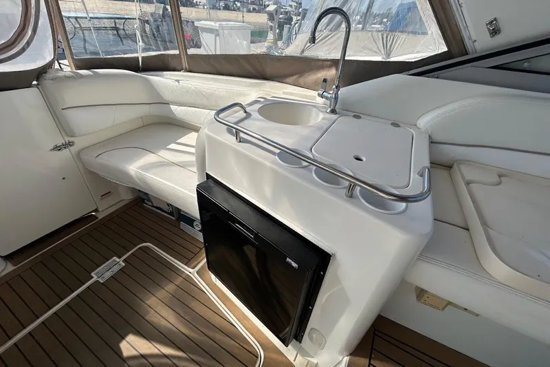 Slide: The Image of 2001 Larson Cabrio 330 interior with white seating, sink, and wooden flooring. - 4