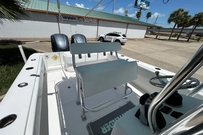 Slide: The Image of 2018 Contender 28 Tournament boat with dual engines, parked near a building and palm trees. - 12