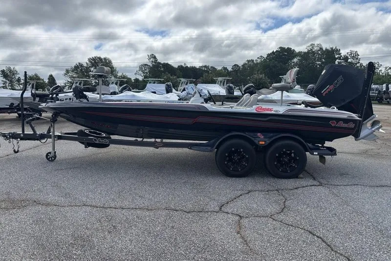 Slide: The Image of 2020 Bass Cat Cougar FTD boat on trailer, parked outdoors under cloudy sky. - 20