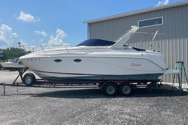 Slide: The Image of 2003 Rinker Fiesta Vee 270 boat on trailer, parked outdoors near a building. - 2