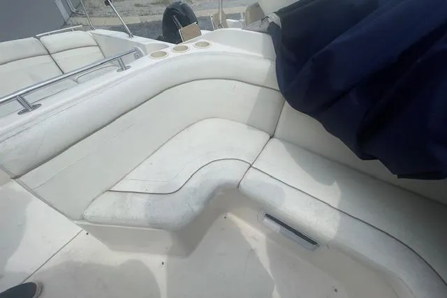 Slide: The Image of 2003 Rinker Fiesta Vee 270 boat interior with white seating and cup holders. - 5