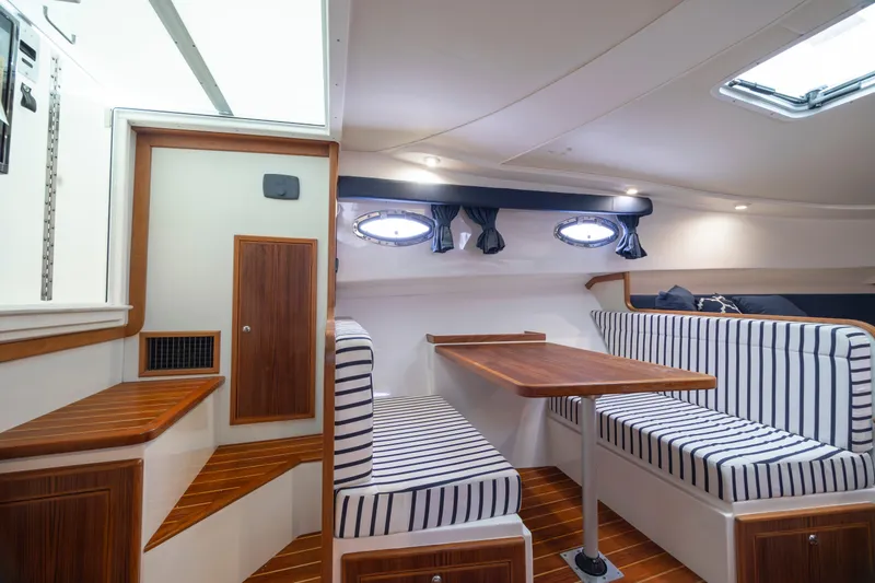 Slide: The Image of 2017 Stamas 370 Aegean interior with striped seating and wooden table. - 28