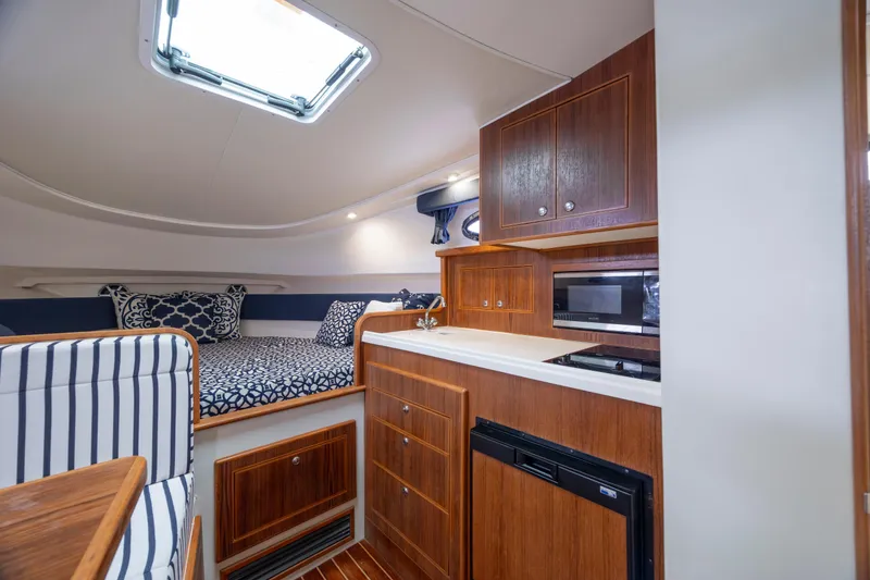 Slide: The Image of 2017 Stamas 370 Aegean cabin interior with kitchenette, bed, and wooden cabinetry. - 32