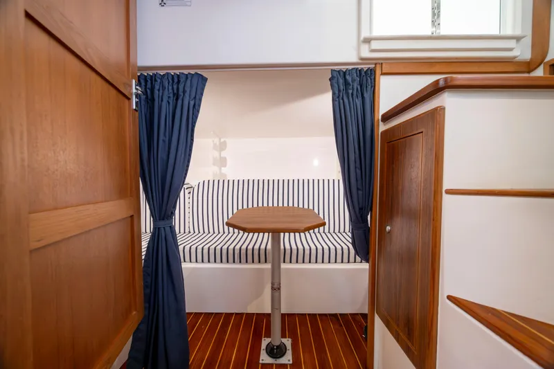Slide: The Image of 2017 Stamas 370 Aegean cabin interior with striped seating, wooden accents, and blue curtains. - 37