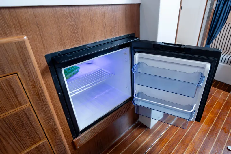 Slide: The Image of Open refrigerator in 2017 Stamas 370 Aegean boat interior, wooden paneling, and blue lighting. - 40