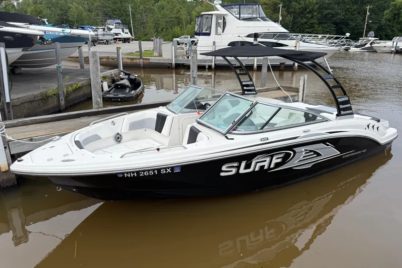 The Image of 2024 Chaparral 23 Surf boat docked at a marina, featuring sleek design and modern features. - 0