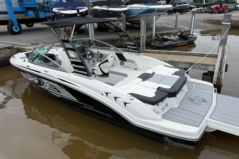 Slide: The Image of 2024 Chaparral 23 Surf boat docked, featuring sleek design and spacious seating. - 4