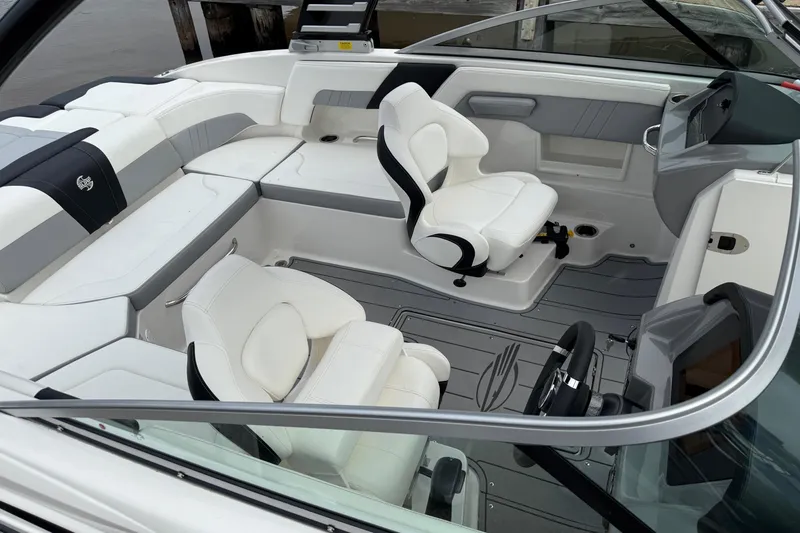 Slide: The Image of 2024 Chaparral 23 Surf boat interior with white seating and modern dashboard design. - 9