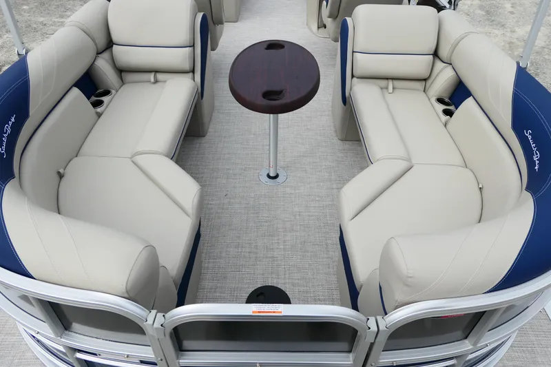 Slide: The Image of 2022 South Bay 224 RS pontoon boat interior with plush seating and central table. - 4