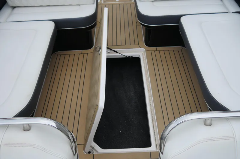 Slide: The Image of 2018 Regal 2800 Bowrider interior with open storage compartment and cushioned seating. - 11