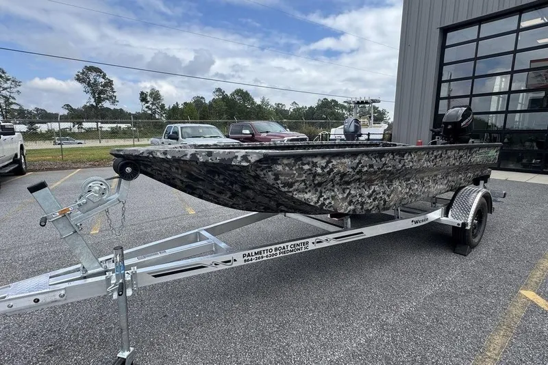 Slide: The Image of 2024 Havoc 1756 MRST boat on trailer, camo design, parked outside dealership. - 2