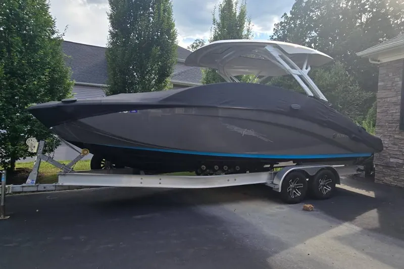 Slide: The Image of 2022 Yamaha Boats 275 SD on trailer, covered, parked in driveway. - 1