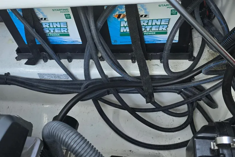 Slide: The Image of 2022 Yamaha Boats 275 SD engine compartment with Marine Master batteries and wiring. - 15