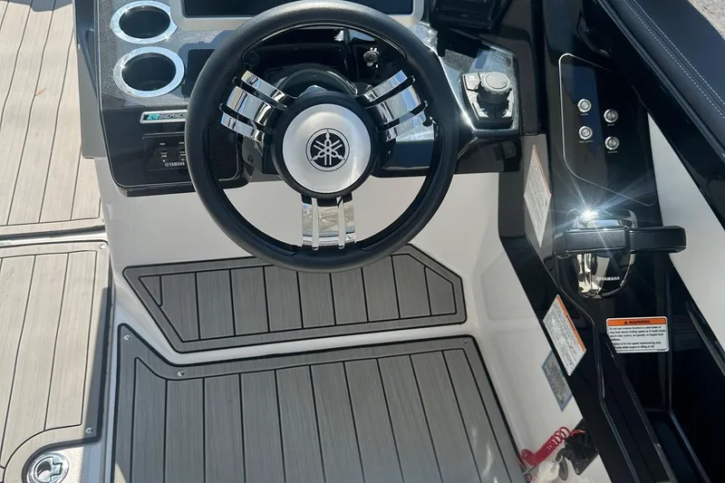 Slide: The Image of 2022 Yamaha Boats 275SD steering wheel and control panel, featuring sleek design and modern controls. - 25