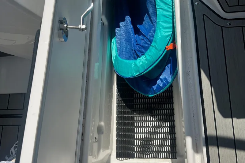 Slide: The Image of Storage compartment on 2022 Yamaha Boats 275SD, featuring a blue collapsible container. - 27