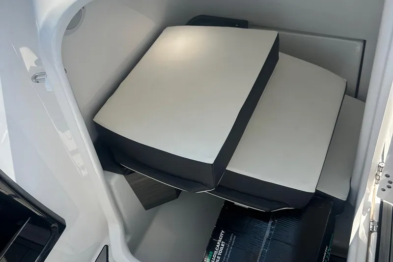 Slide: The Image of 2022 Yamaha Boats 275SD interior storage with stacked cushions. - 31