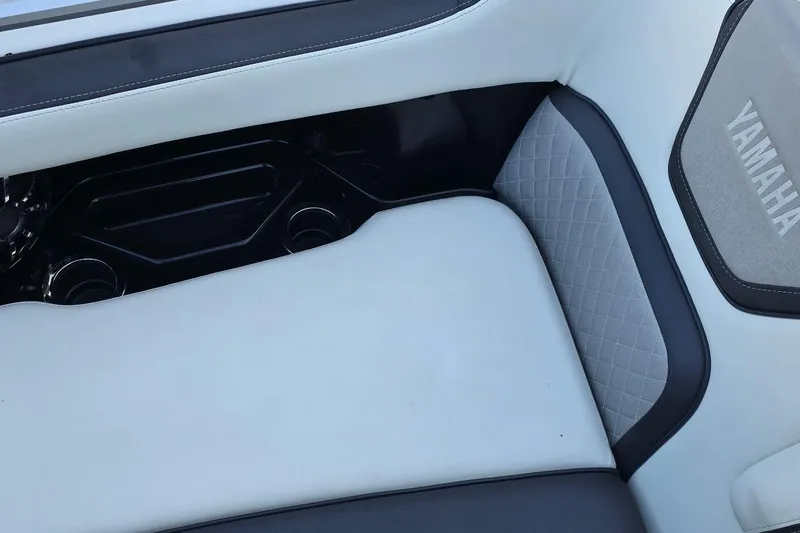 Slide: The Image of Luxurious seating detail on 2022 Yamaha Boats 275 SD, featuring elegant stitching and cup holders. - 35