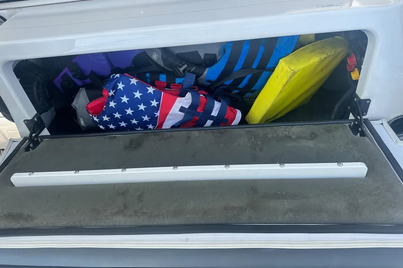 Slide: The Image of Storage compartment of 2022 Yamaha Boats 275SD with life jackets and gear. - 39