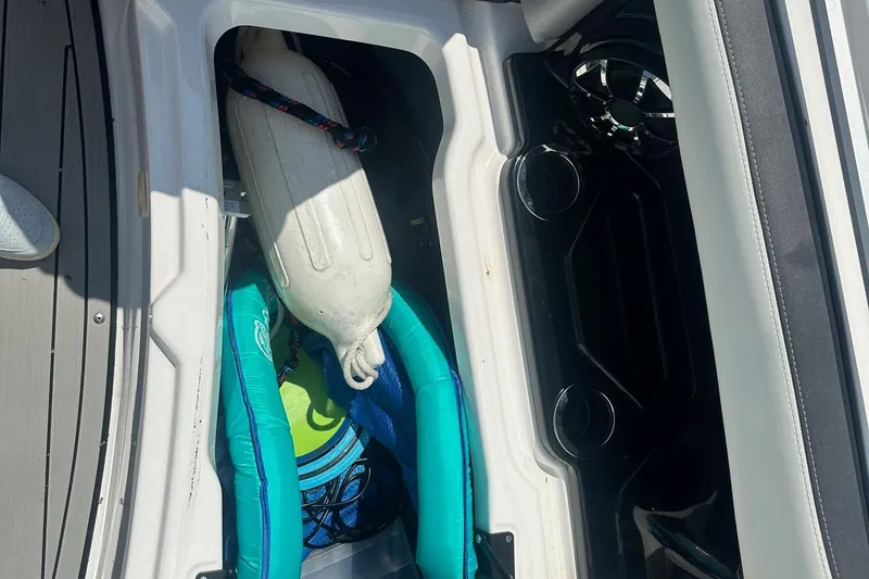 Slide: The Image of Storage compartment in 2022 Yamaha Boats 275SD with fender and life jacket. - 40