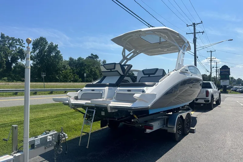 Slide: The Image of 2022 Yamaha Boats 275SD on trailer, parked outdoors under clear blue sky. - 5