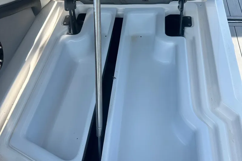 Slide: The Image of 2022 Yamaha Boats 275SD storage compartment with open lid and hydraulic support. - 8