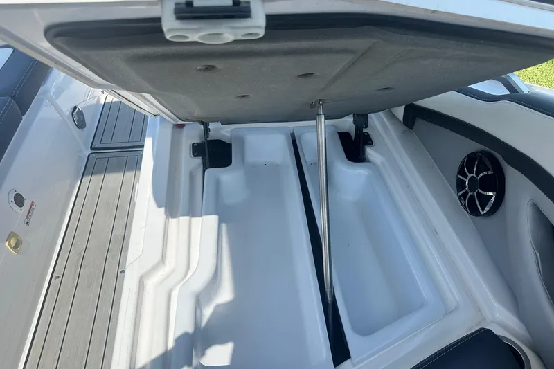 Slide: The Image of Open storage compartment in 2022 Yamaha Boats 275SD, featuring sleek design and speaker detail. - 9