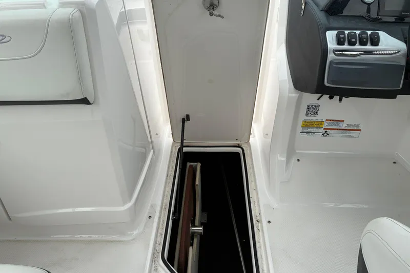 Slide: The Image of 2020 Regal 23 OBX boat interior with open storage compartment and control panel. - 16