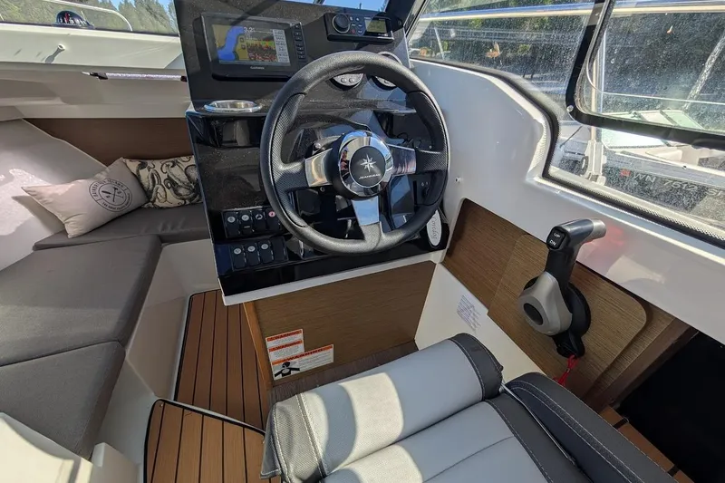 Slide: The Image of Interior of 2020 Jeanneau NC 695 Series 2 boat, featuring steering wheel and seating. - 10