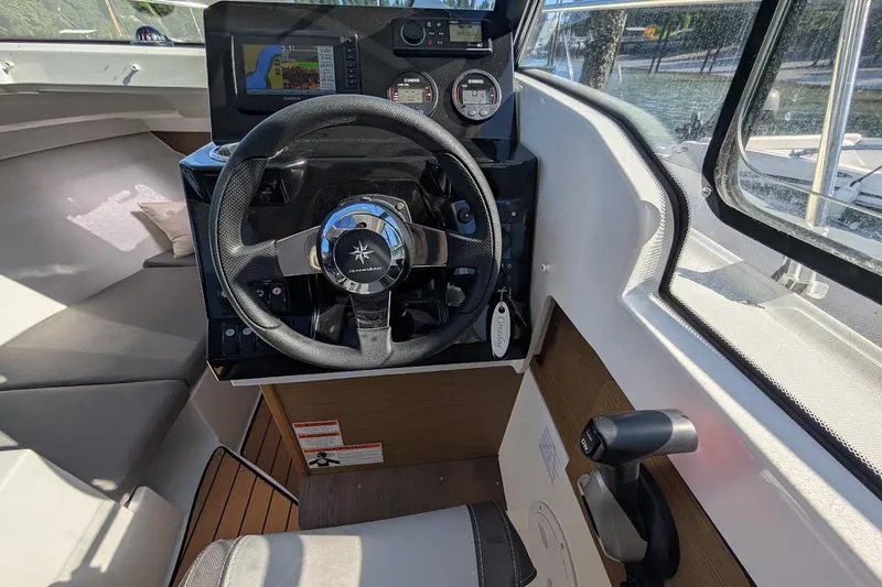Slide: The Image of 2020 Jeanneau NC 695 Series 2 helm with steering wheel and navigation controls. - 11