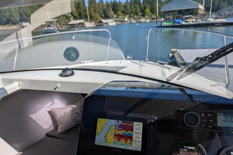 Slide: The Image of 2020 Jeanneau NC 695 Series 2 boat dashboard with navigation system, docked at marina. - 12
