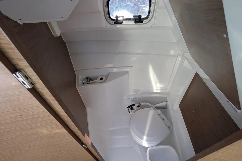 Slide: The Image of 2020 Jeanneau NC 695 Series 2 boat bathroom with compact toilet and window. - 14