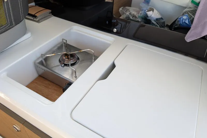 Slide: The Image of Compact kitchen area in 2020 Jeanneau NC 695 Series 2 boat with stove and storage. - 15