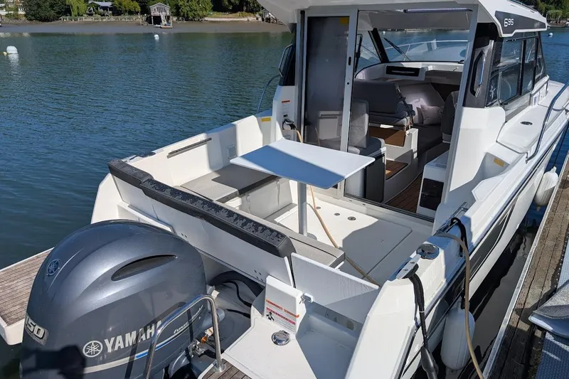 Slide: The Image of 2020 Jeanneau NC 695 Series 2 boat with Yamaha engine, docked on a serene lake. - 5