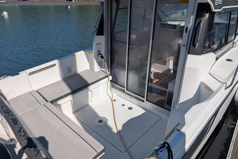 Slide: The Image of 2020 Jeanneau NC 695 Series 2 boat with spacious deck and sliding glass doors. - 6