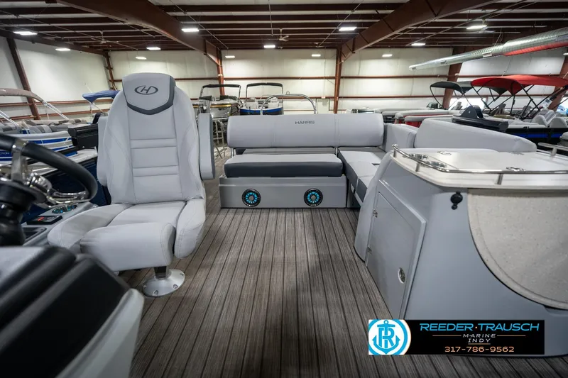 Slide: The Image of 2020 Harris Solstice boat interior with spacious seating and modern design in a showroom. - 15