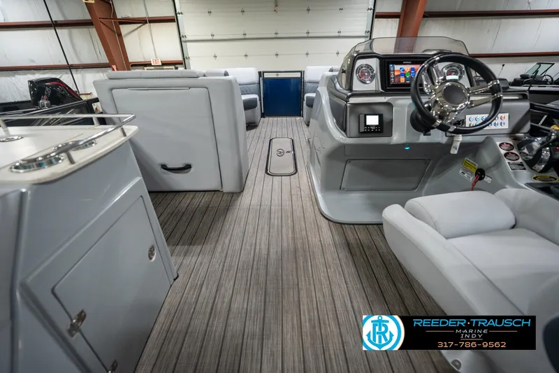 Slide: The Image of 2020 Harris Solstice boat interior with plush seating in a showroom. - 18