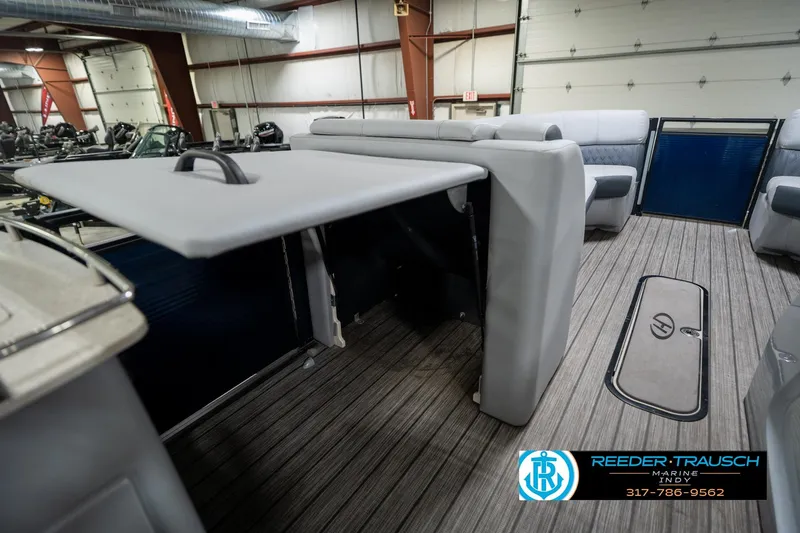 Slide: The Image of 2020 Harris Solstice boat interior with seating and flooring, displayed in a showroom. - 26