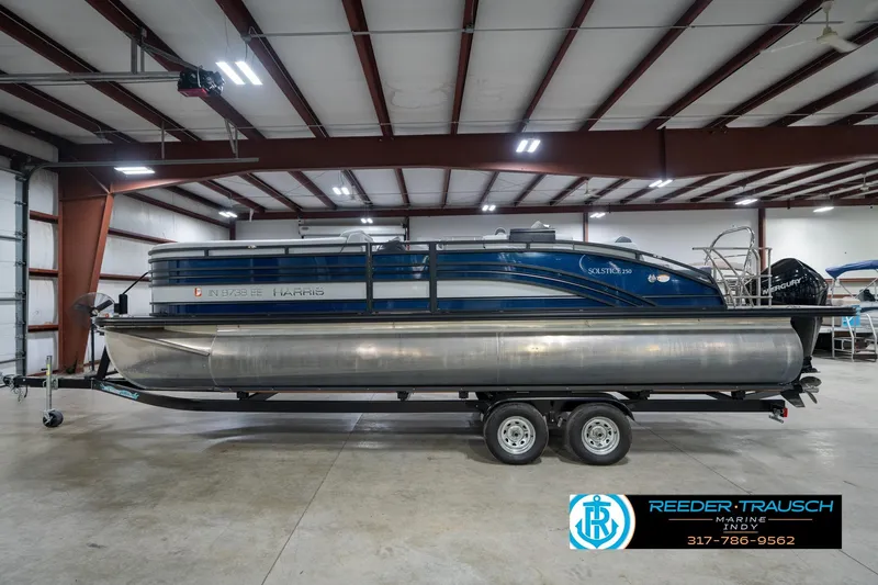 Slide: The Image of 2020 Harris Solstice boat in indoor showroom, featuring Mercury engine. - 9