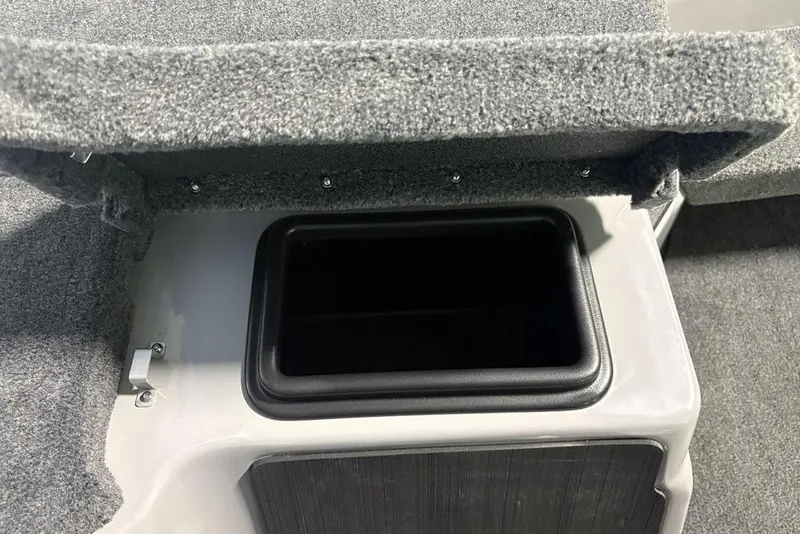 Slide: The Image of Open storage compartment in 2026 Skeeter ZXR20 SE boat, featuring carpeted interior. - 18