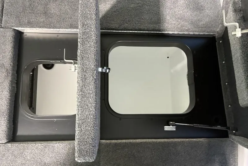 Slide: The Image of 2026 Skeeter ZXR20 SE boat storage compartment with open hatches and carpeted interior. - 33