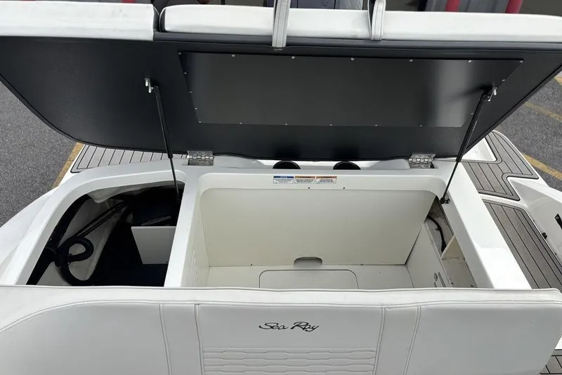 Slide: The Image of 2023 Sea Ray SPX 210 Outboard boat storage compartment with open lid, showcasing interior space. - 12